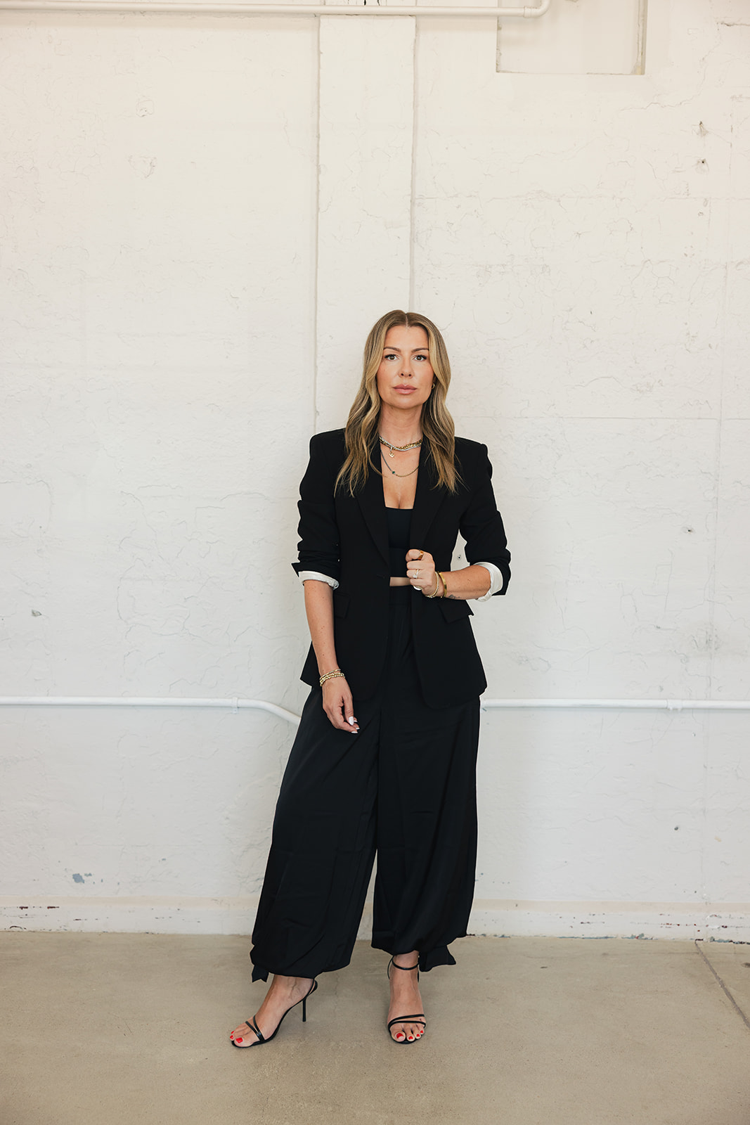 Black blazer, jeans, heels in window light — elevated occasion styling