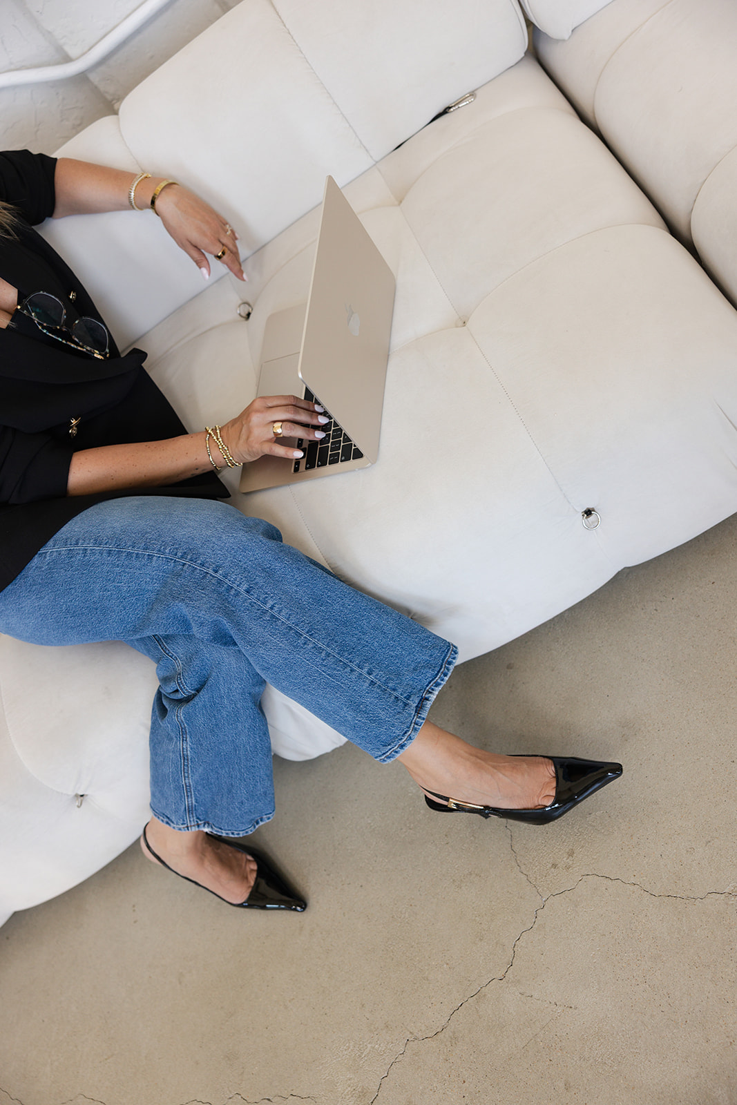 Blazer, sunglasses, and laptop detail — polished style